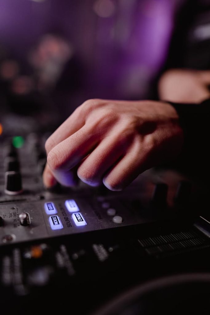 Photo of a Person's Hand Using a Dj Mixer